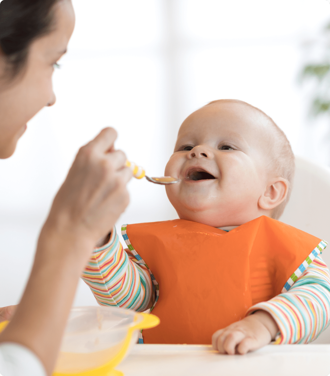 Close up of mother spoon feeding baby